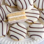 A close-up view of a white plate with zebra cakes, featuring chocolate and vanilla stripes.