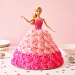 Barbie cake designed with a pink fondant gown, floral accents, and a Barbie doll centerpiece, perfect for celebrations.